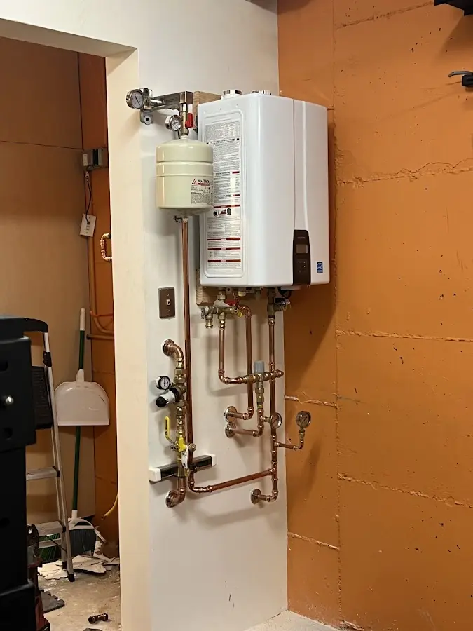 Plumbing technician inspecting water heater connections in Ipswich